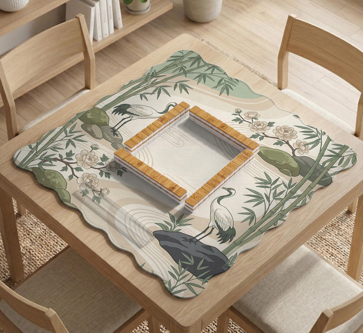 Square mahjong mat with a cream background, sage green cranes, bamboo leaves, peony branches, stones, and thin linework.