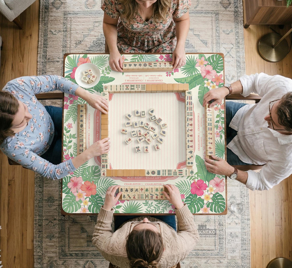 Coral tropical floral mahjong mat with hibiscus flowers, palm leaves, cream sections, and a scalloped edge.
