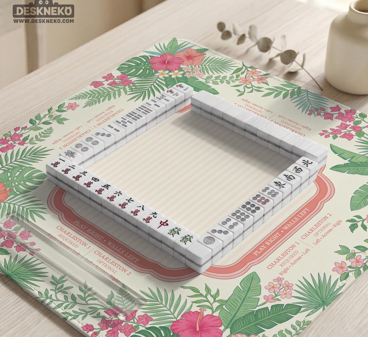 Coral tropical floral mahjong mat with hibiscus flowers, palm leaves, cream sections, and a scalloped edge.