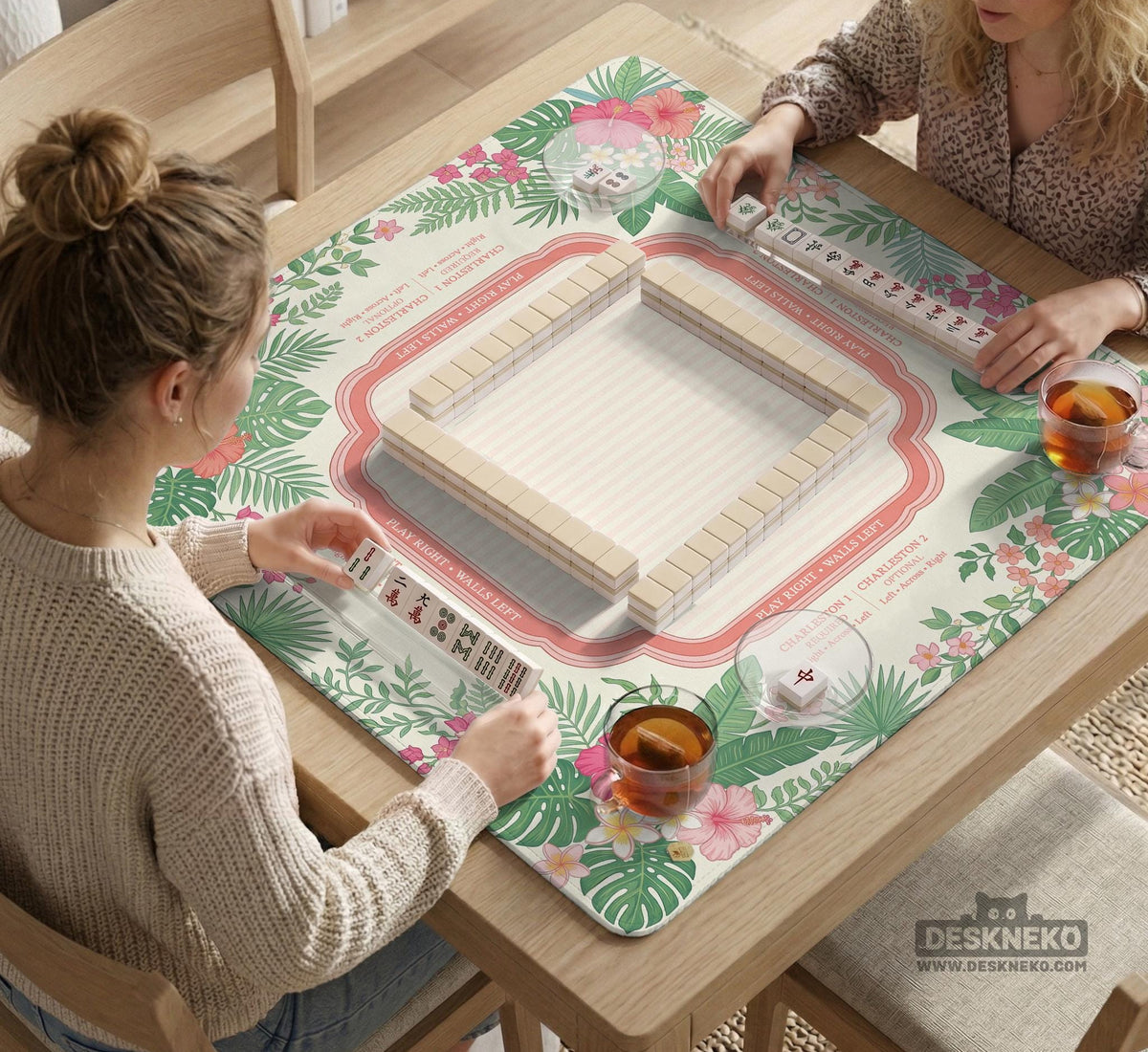 Coral tropical floral mahjong mat with hibiscus flowers, palm leaves, cream sections, and a scalloped edge.