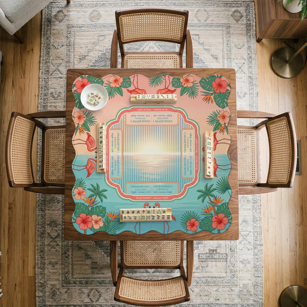 A square mahjong mat with flamingos, hibiscus flowers, palm leaves, and aqua water accents on a coral background with a scalloped edge.
