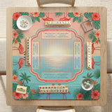 A square mahjong mat with flamingos, hibiscus flowers, palm leaves, and aqua water accents on a coral background with a scalloped edge.