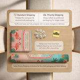 A square mahjong mat with flamingos, hibiscus flowers, palm leaves, and aqua water accents on a coral background with a scalloped edge.