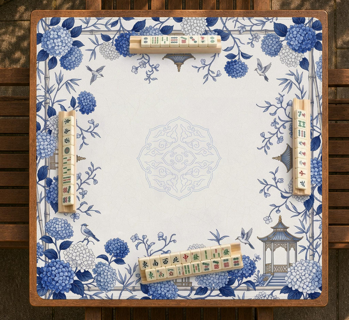 Blue and white square mahjong mat with a hydrangea and bird botanical border and a plain center area.