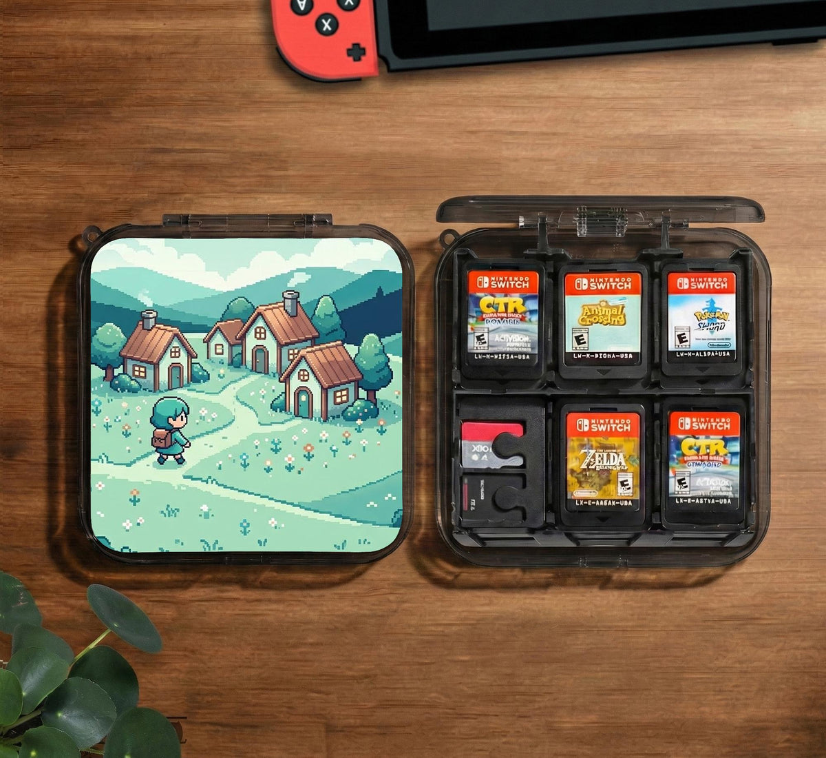 Teal carrying case with a pixel-style village scene, small houses, layered mountains, flowers, and a retro game-inspired landscape design.