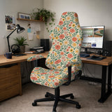 Cream desk chair cover with a vintage floral print featuring coral roses, mustard daisies, and green vines on a chair.