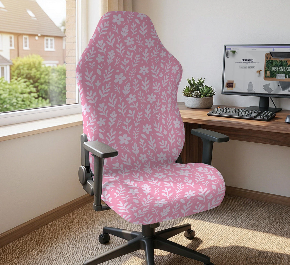Soft pink floral chair cover shown on a gaming chair with a high back and armrests.