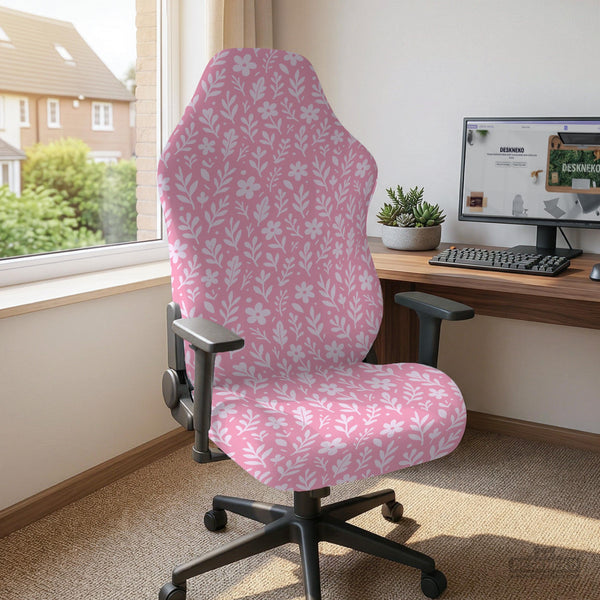 Soft pink floral chair cover shown on a gaming chair with a high back and armrests.