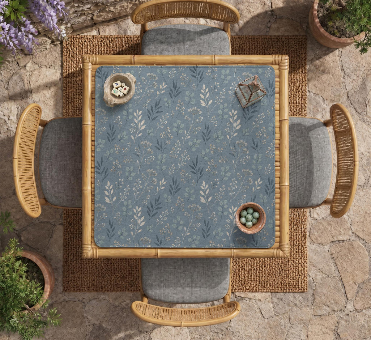 Blue mahjong mat with a botanical floral pattern, pale leaves, and delicate stems on a dusty blue background.
