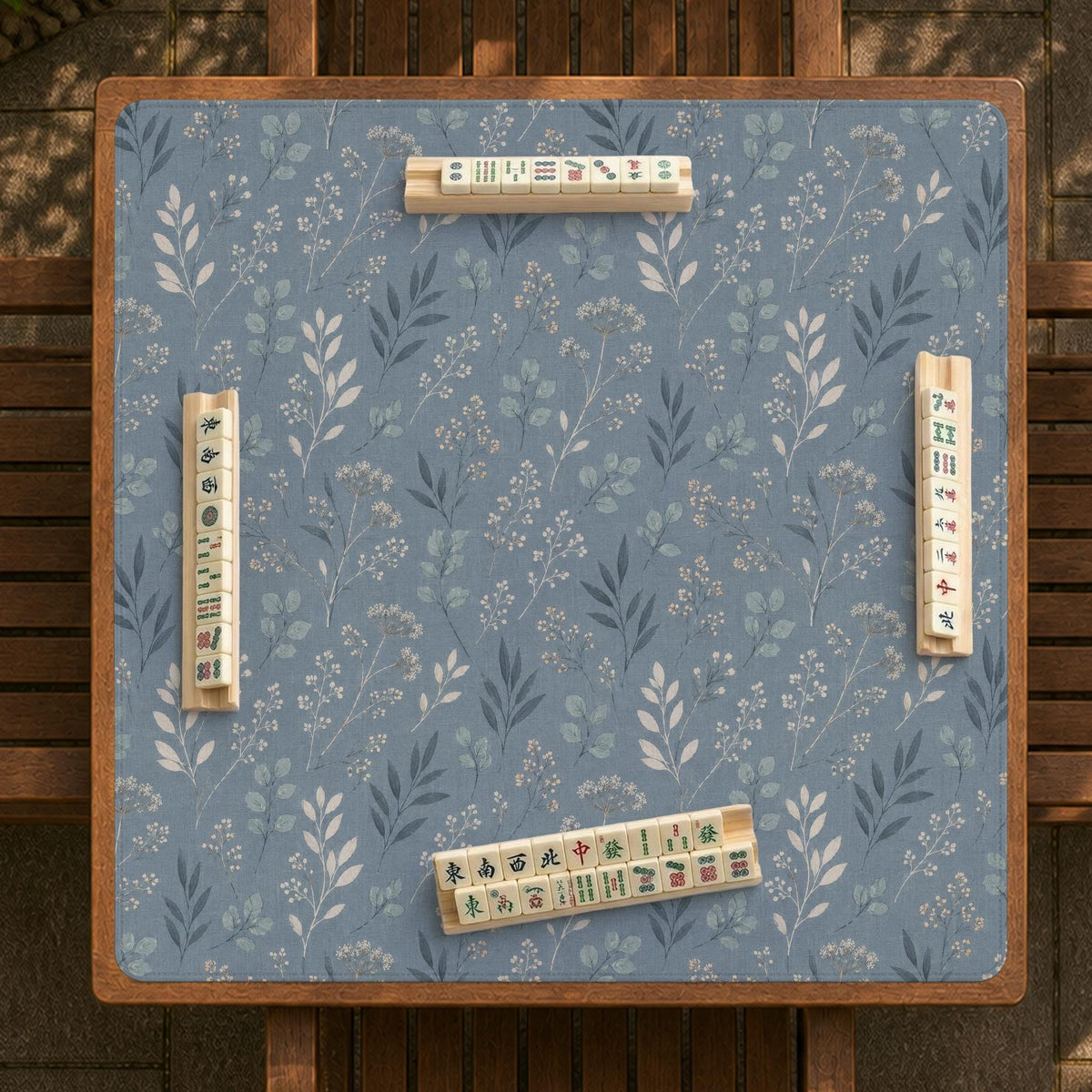 Blue mahjong mat with a dusty linen-look background and small leafy botanical stems in a floral pattern.