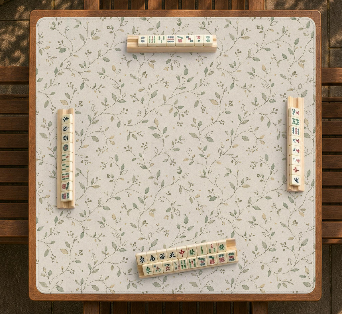 Cream square mahjong mat with a sage vine and leaf botanical pattern and scalloped edges.