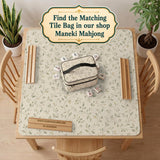 Sage green botanical mahjong mat with a cream background, trailing vines, and muted leaf designs.