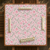 Pink mahjong mat with a tulip floral pattern in blush and sage tones and a scalloped edge.