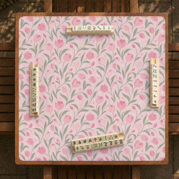 A pink mahjong mat with tulip flowers, sage leaves, and a light pastel background.