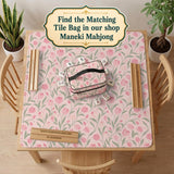 A pink mahjong mat with tulip flowers, sage leaves, and a light pastel background.