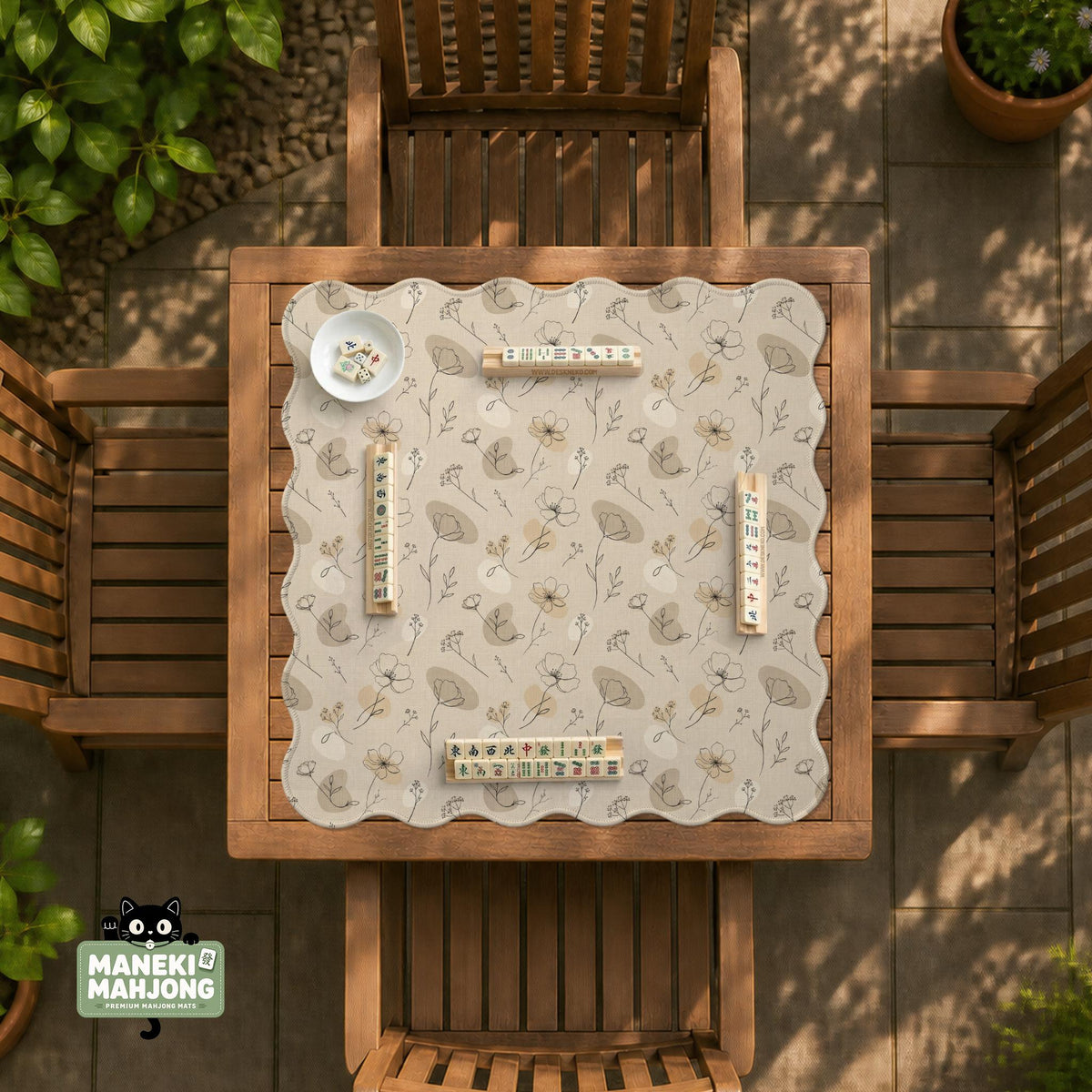 Neutral floral mahjong mat with delicate botanical line art and a scalloped edge on a cream background.
