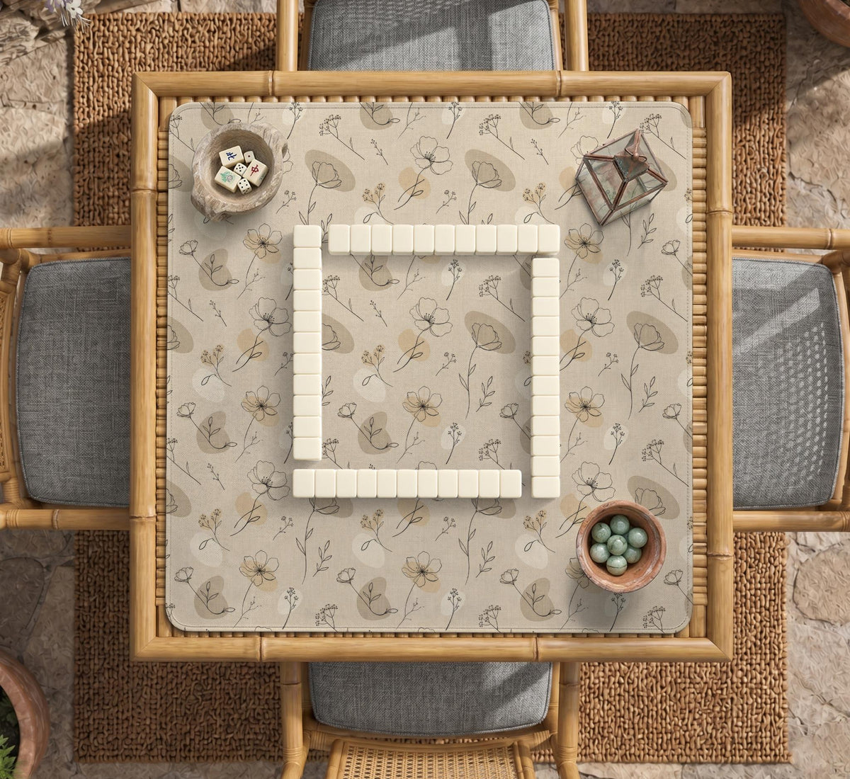 Neutral floral mahjong mat with delicate botanical line art and a scalloped edge on a cream background.