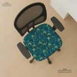 A blue green chair cover with a peacock feather design shown on an office chair with armrests.