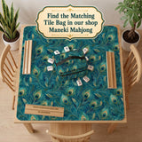 A teal mahjong mat with a peacock feather pattern and scalloped edges.