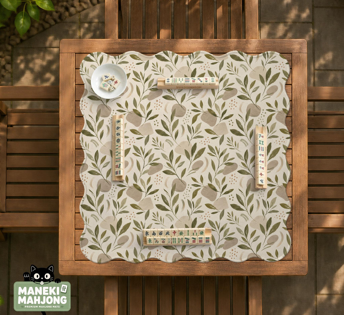 Green botanical mahjong mat with sage leaf and floral design and a scalloped edge.