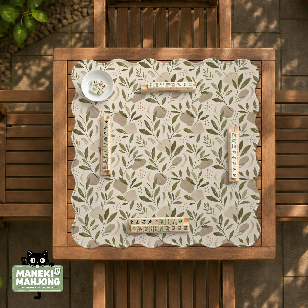 Green botanical mahjong mat with sage leaf and floral design and a scalloped edge.