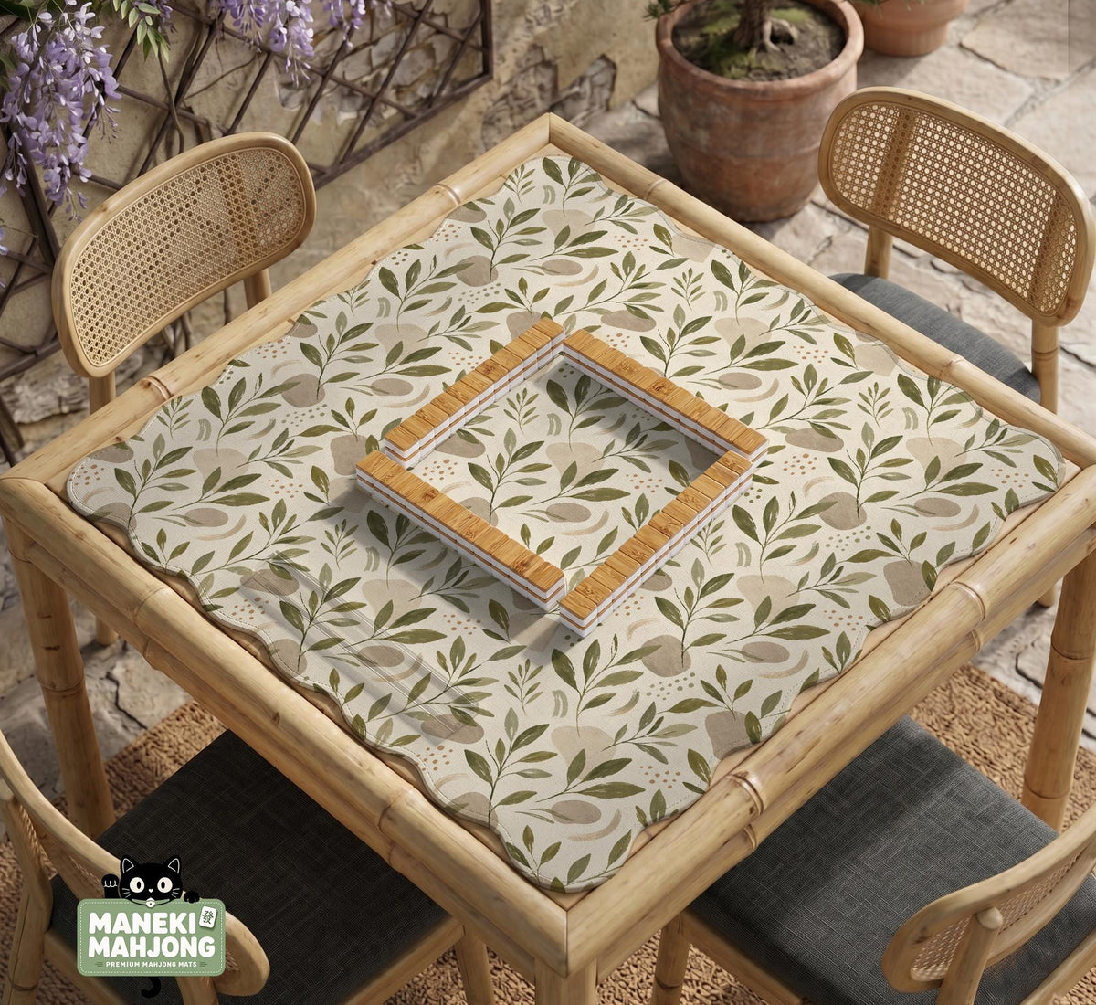 Green botanical mahjong mat with sage leaf and floral design and a scalloped edge.